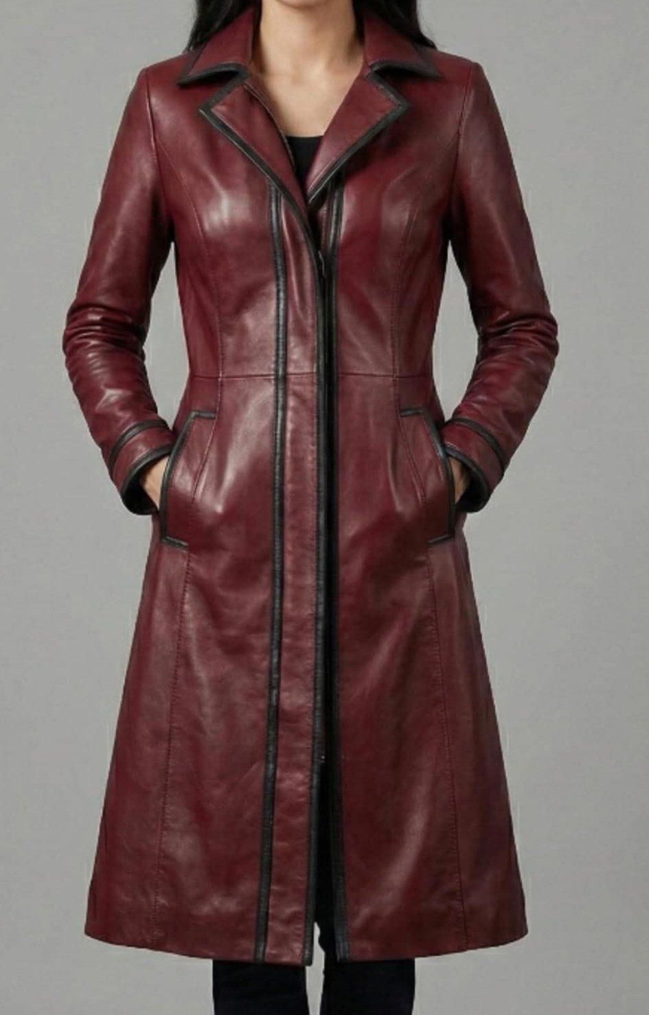 Abrigo de cuero burdeos con ribete negro en una persona, con las manos en los bolsillos.