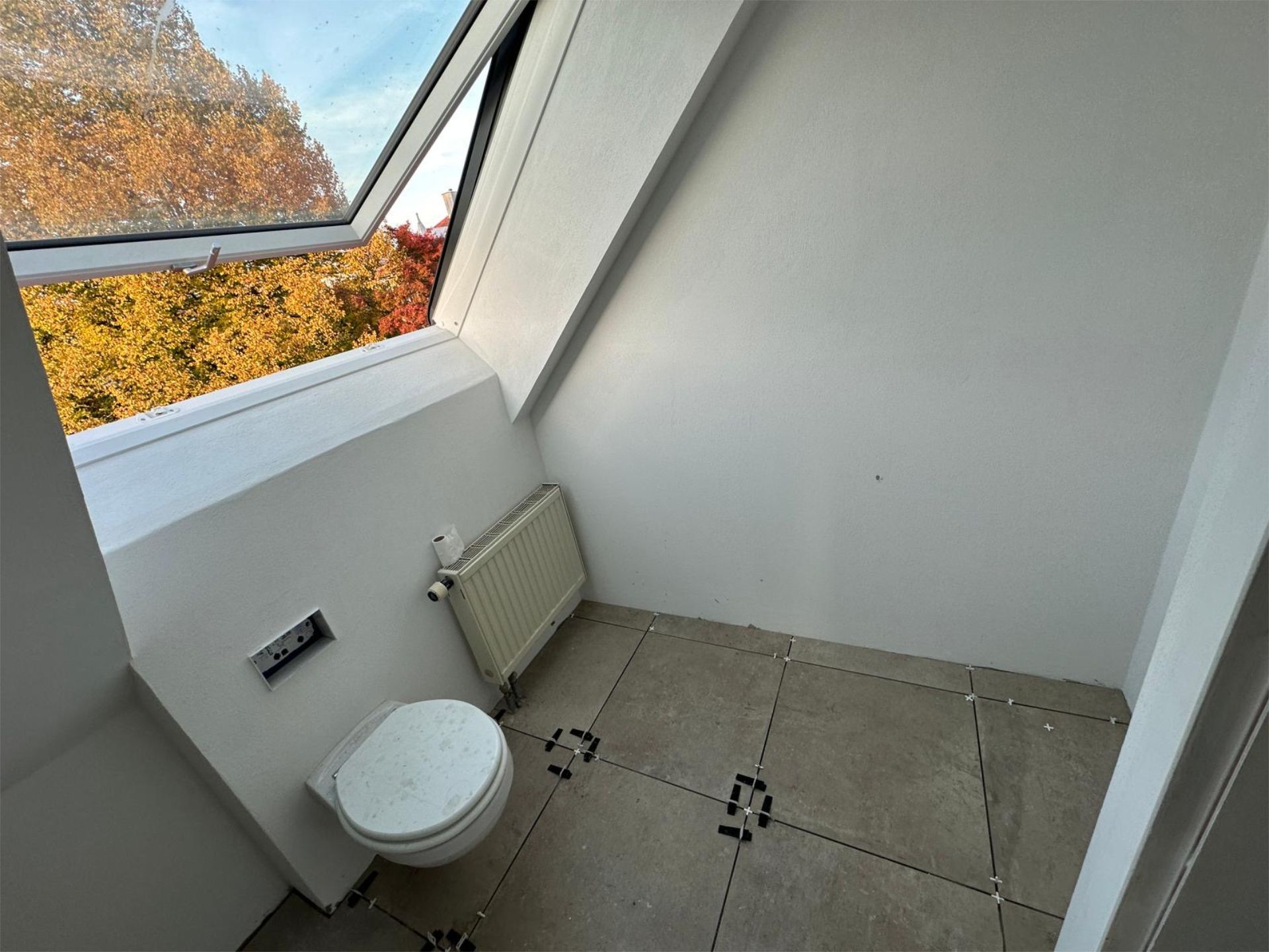 Teilrenoviertes Bad mit Fenster und hellen Wandfliesen