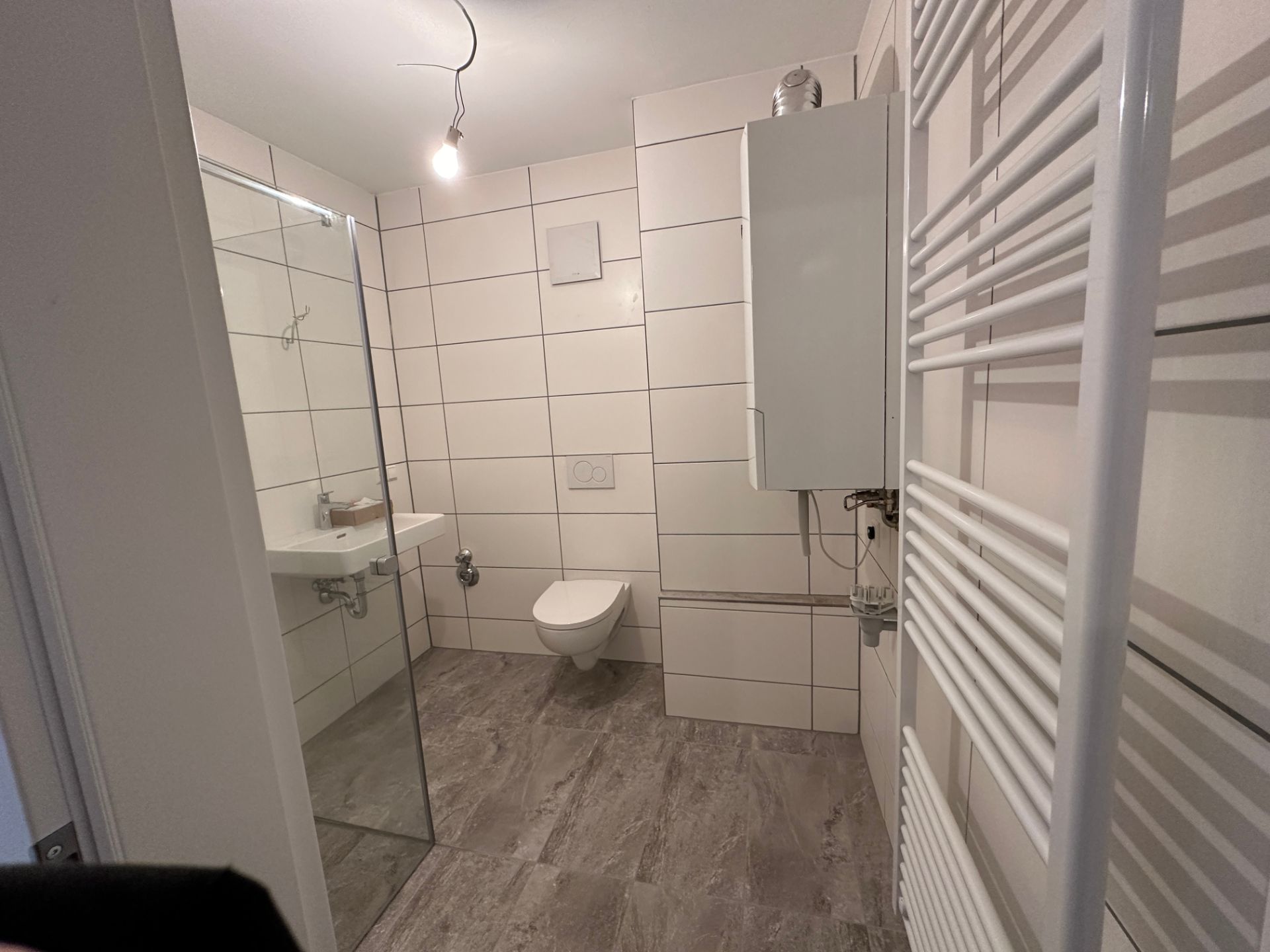 Komplett renoviertes Bad mit Wandfliesen und bodengleicher Dusche