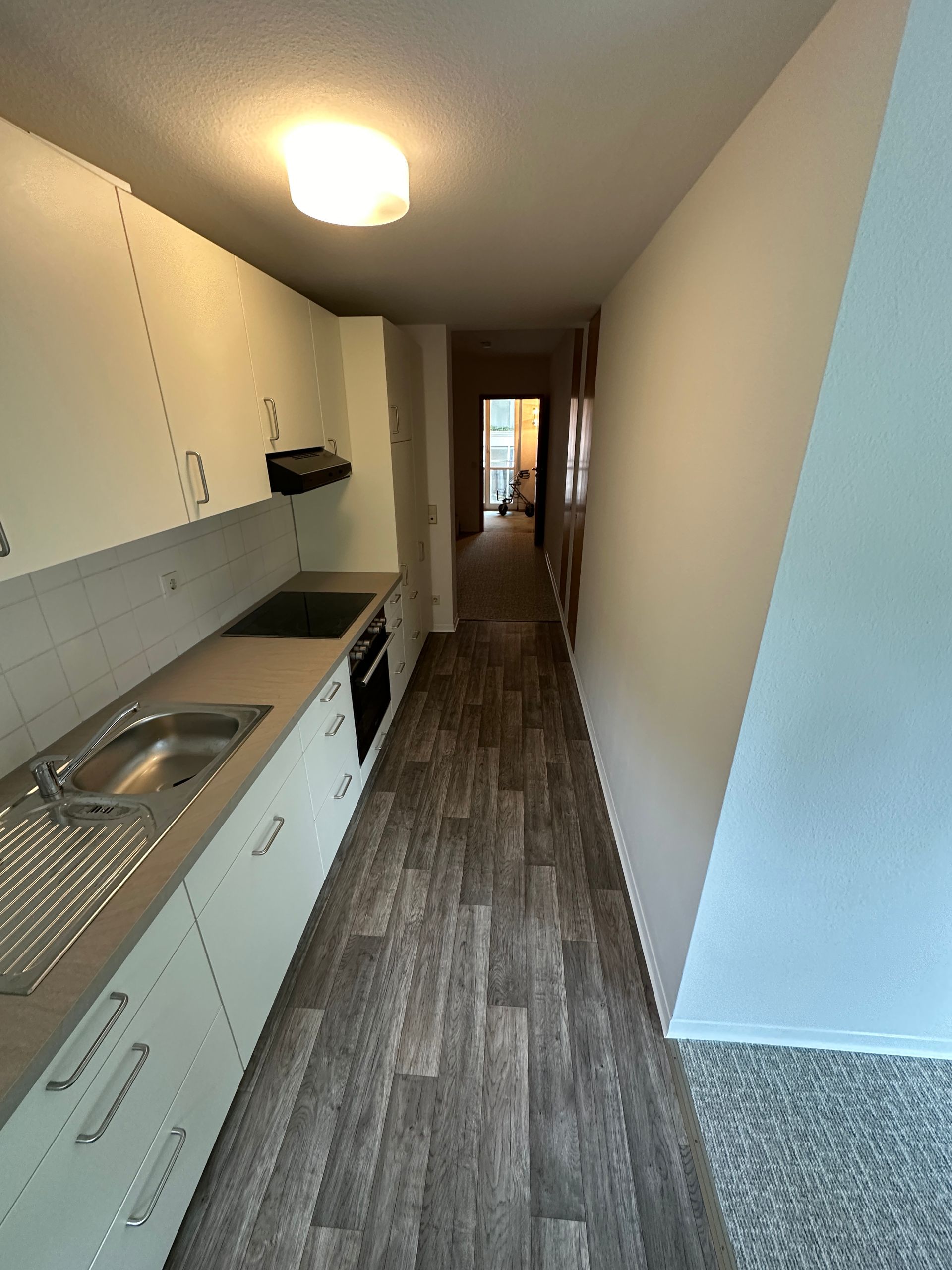 Neue Küchenzeile mit modernen Geräten und grauem Bodenbelag