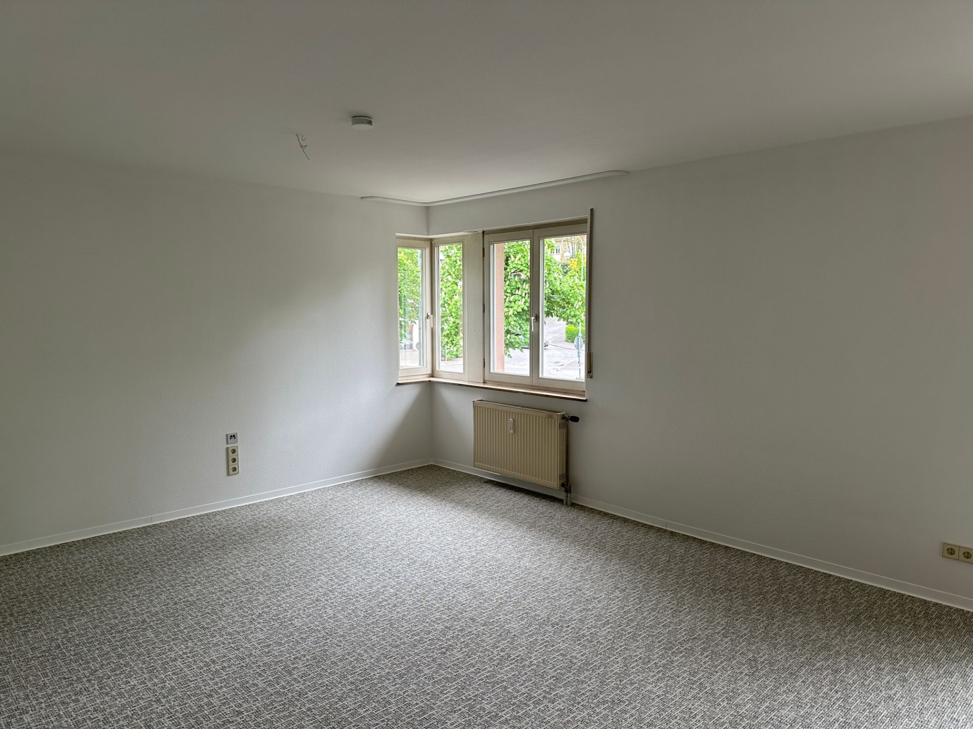 Lichtdurchflutetes Zimmer mit Teppich und frischem Anstrich