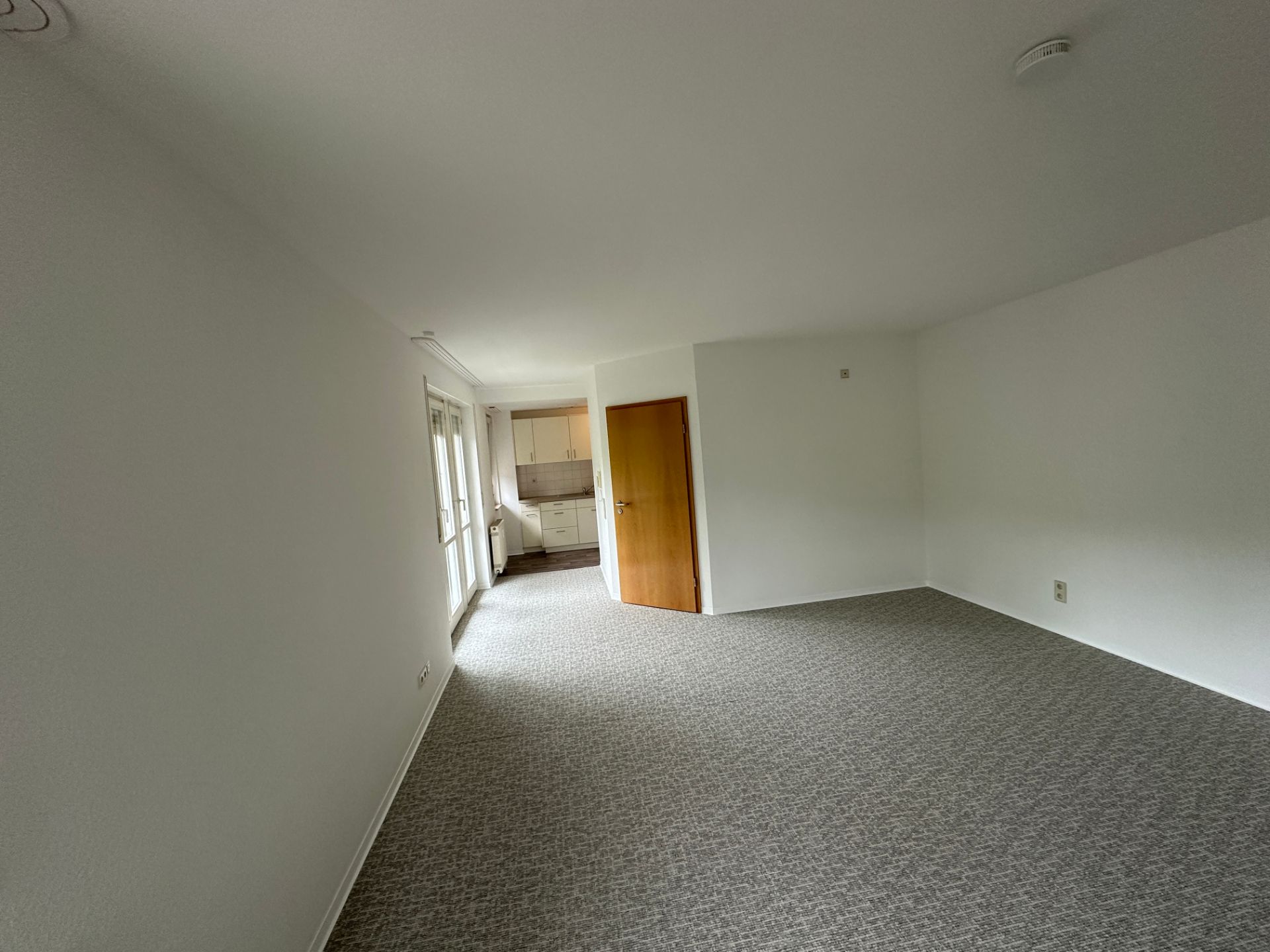 Neubauwohnung mit hellem Teppichboden und weißen Wänden