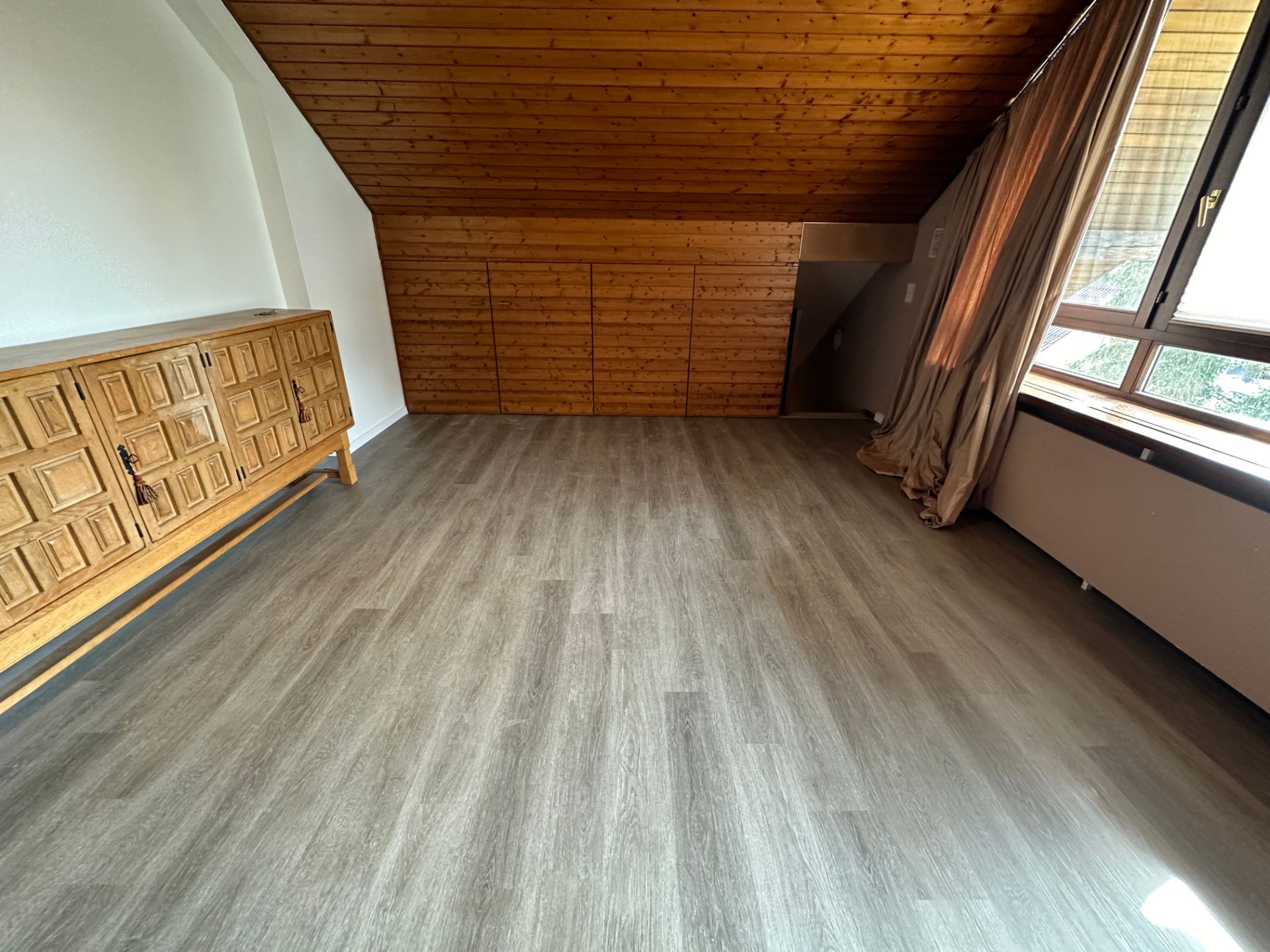 Bodenverlegung im Wohnraum mit Holzdecke