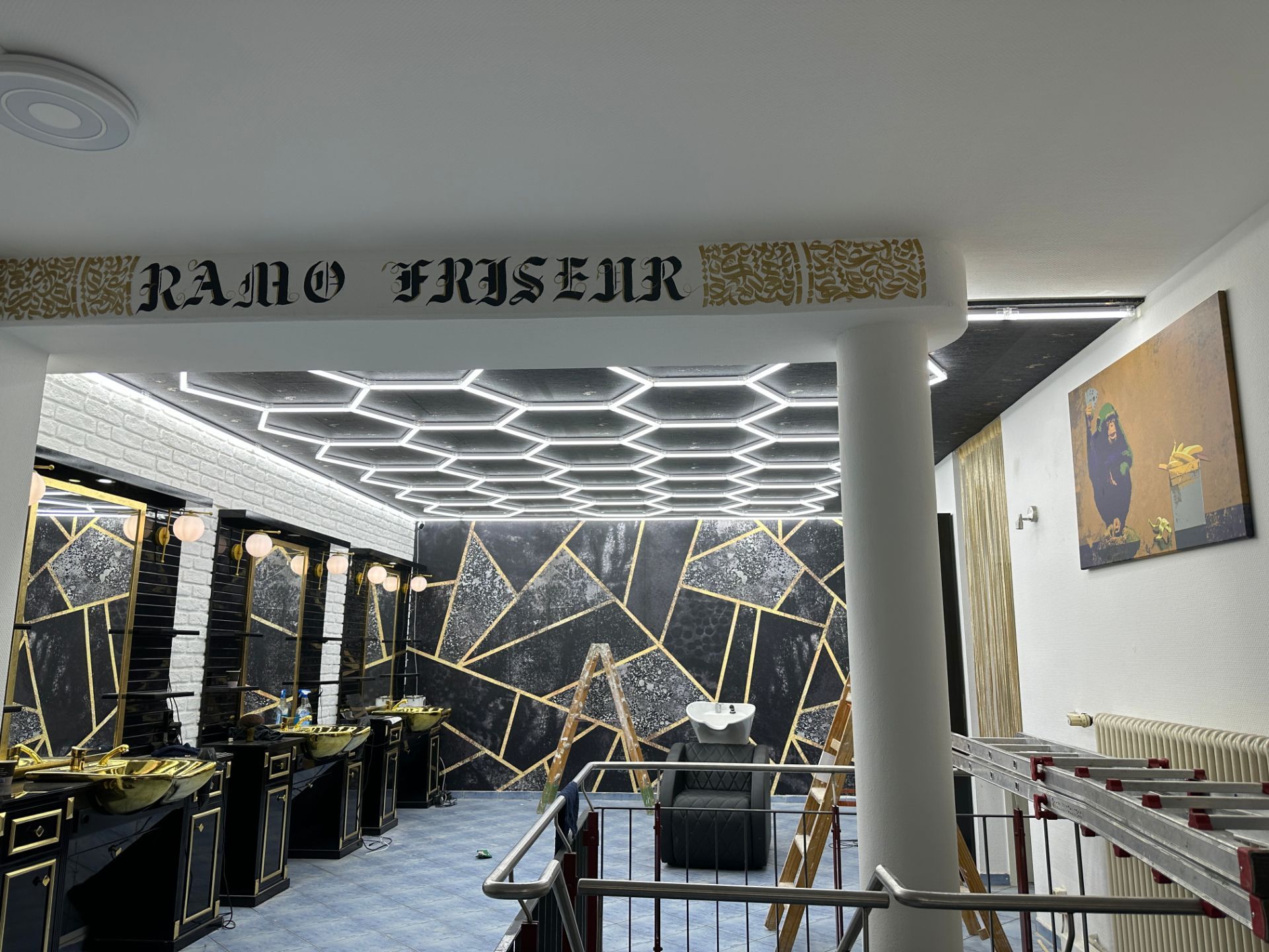 Moderner Friseursalon mit LED-Decke und gold-schwarzer Wandgestaltung