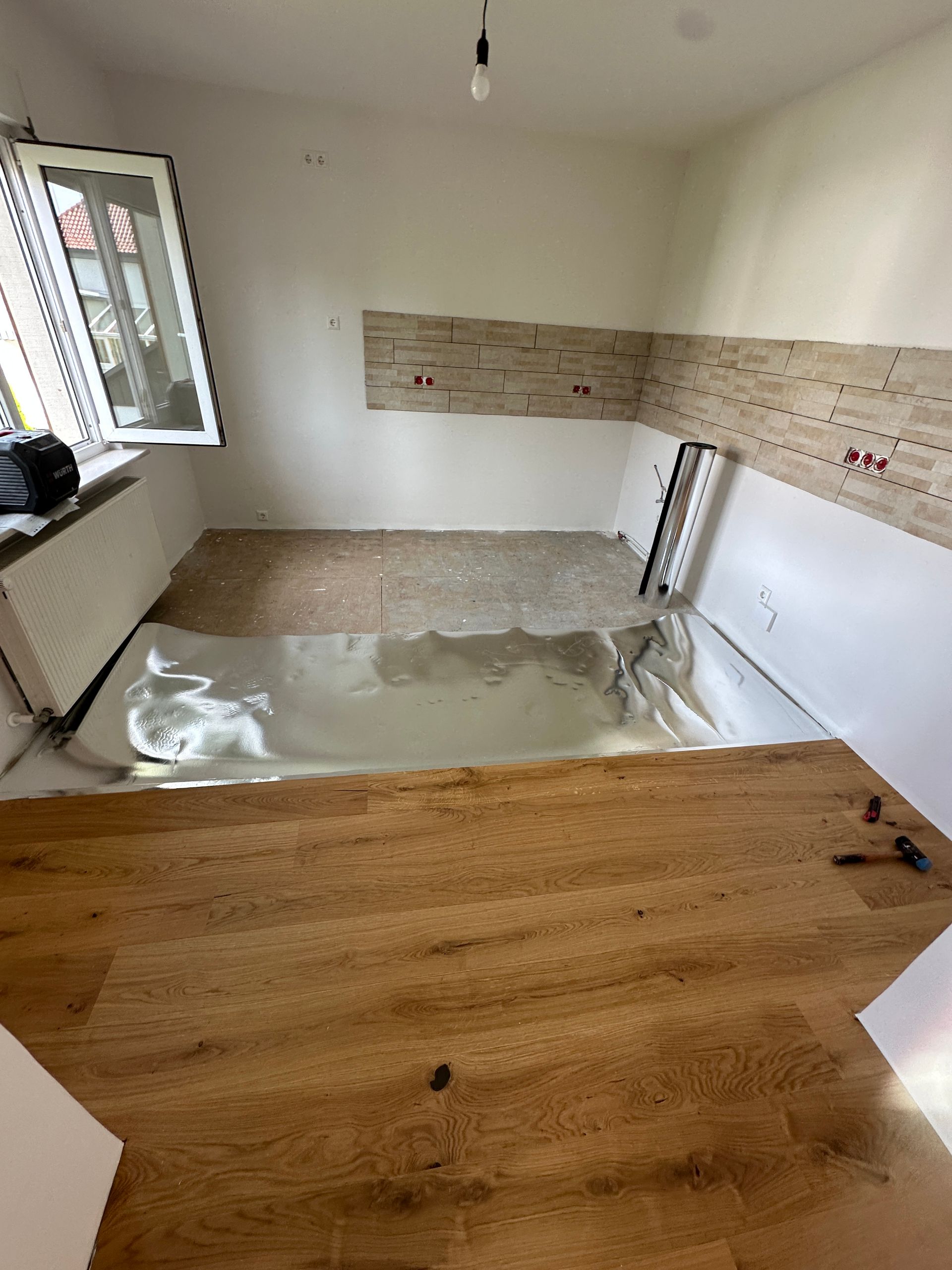 Wohnküche mit Holzparkett und hellen Wänden