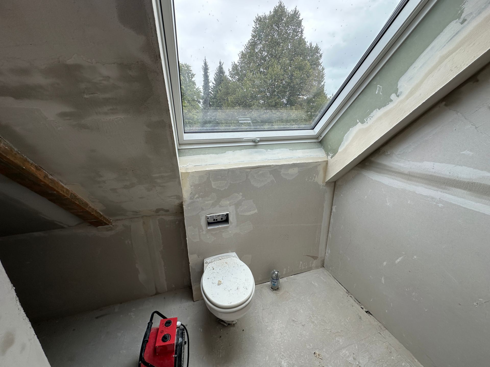 Installation im Bad mit Estrich und Wänden im Rohbauzustand