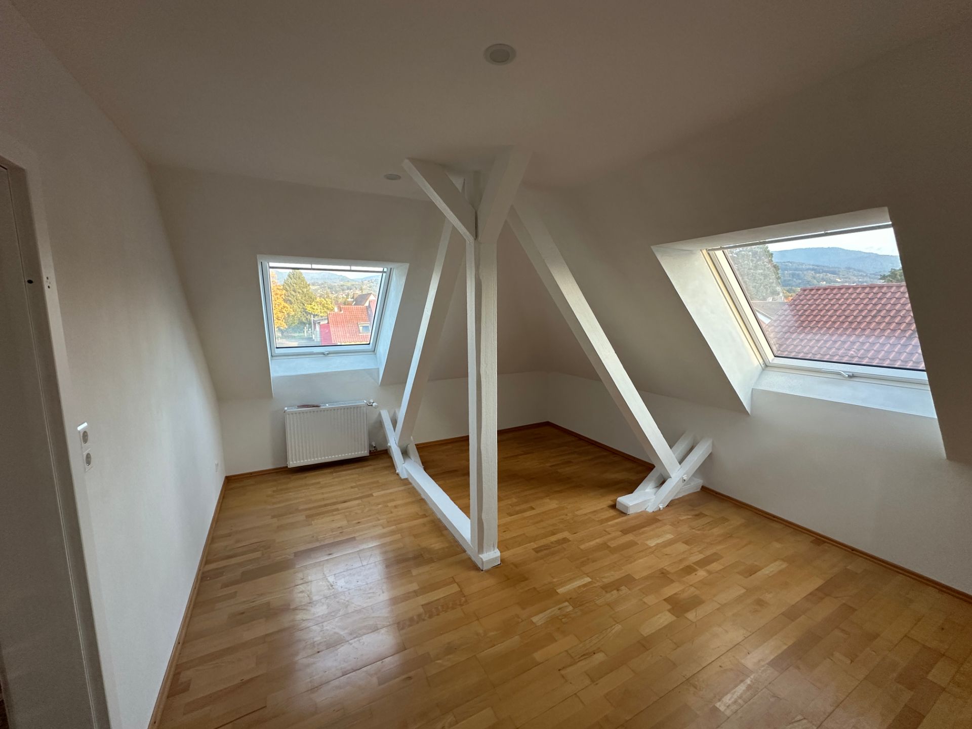 Wohnraum mit weißer Balkenkonstruktion und Parkettboden