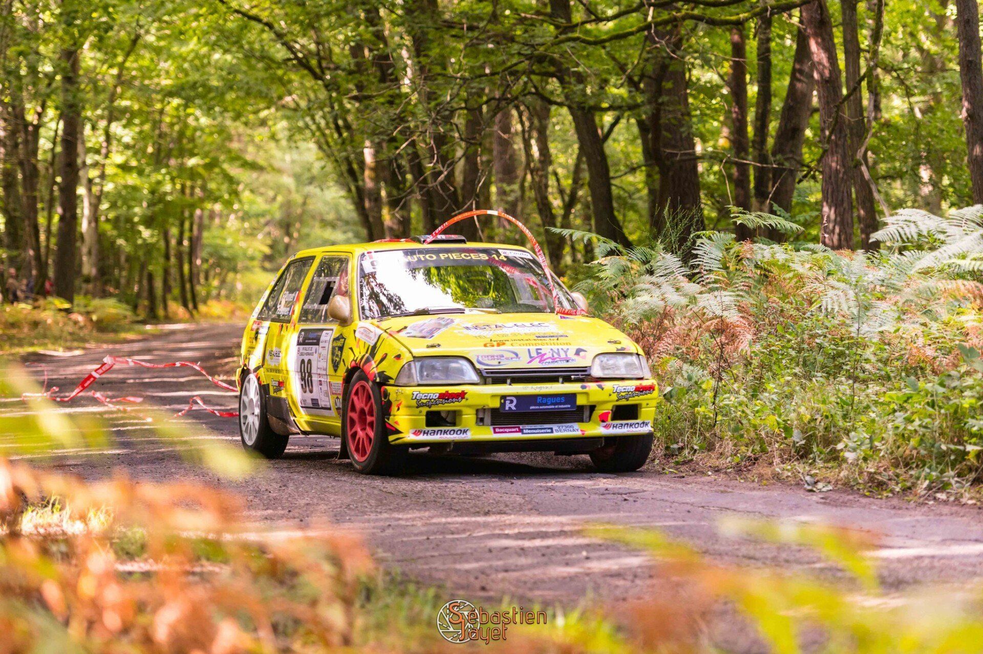 Une voiture de course jaune sur la route.