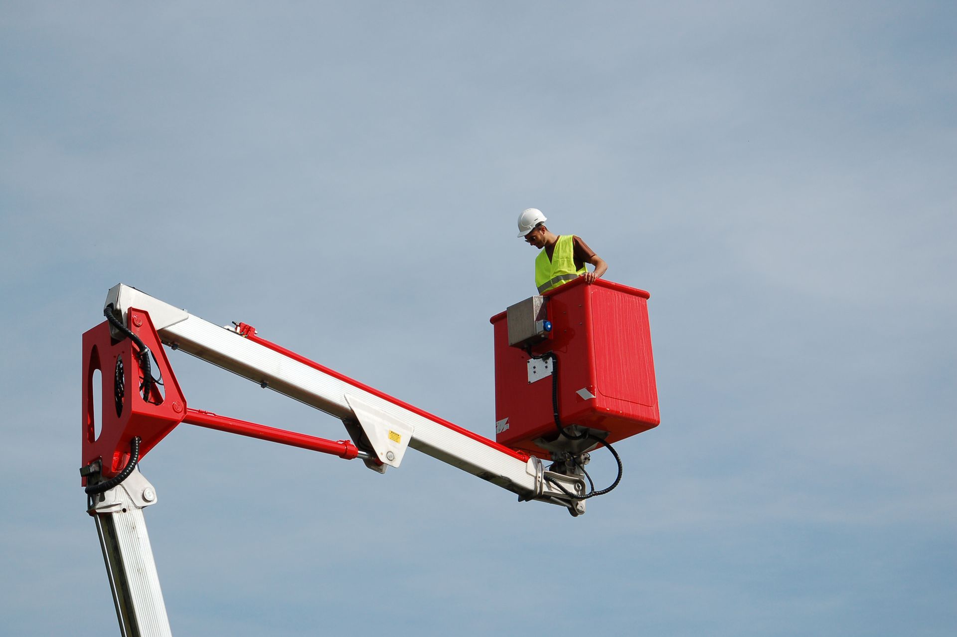 Un professionnel dans le panier de nacelle en hauteur.