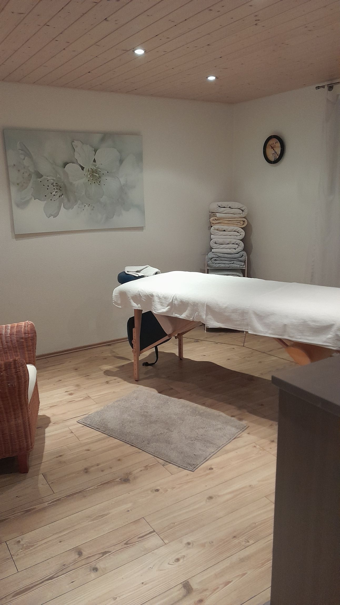 In der Mitte des Raumes steht ein Massagetisch.