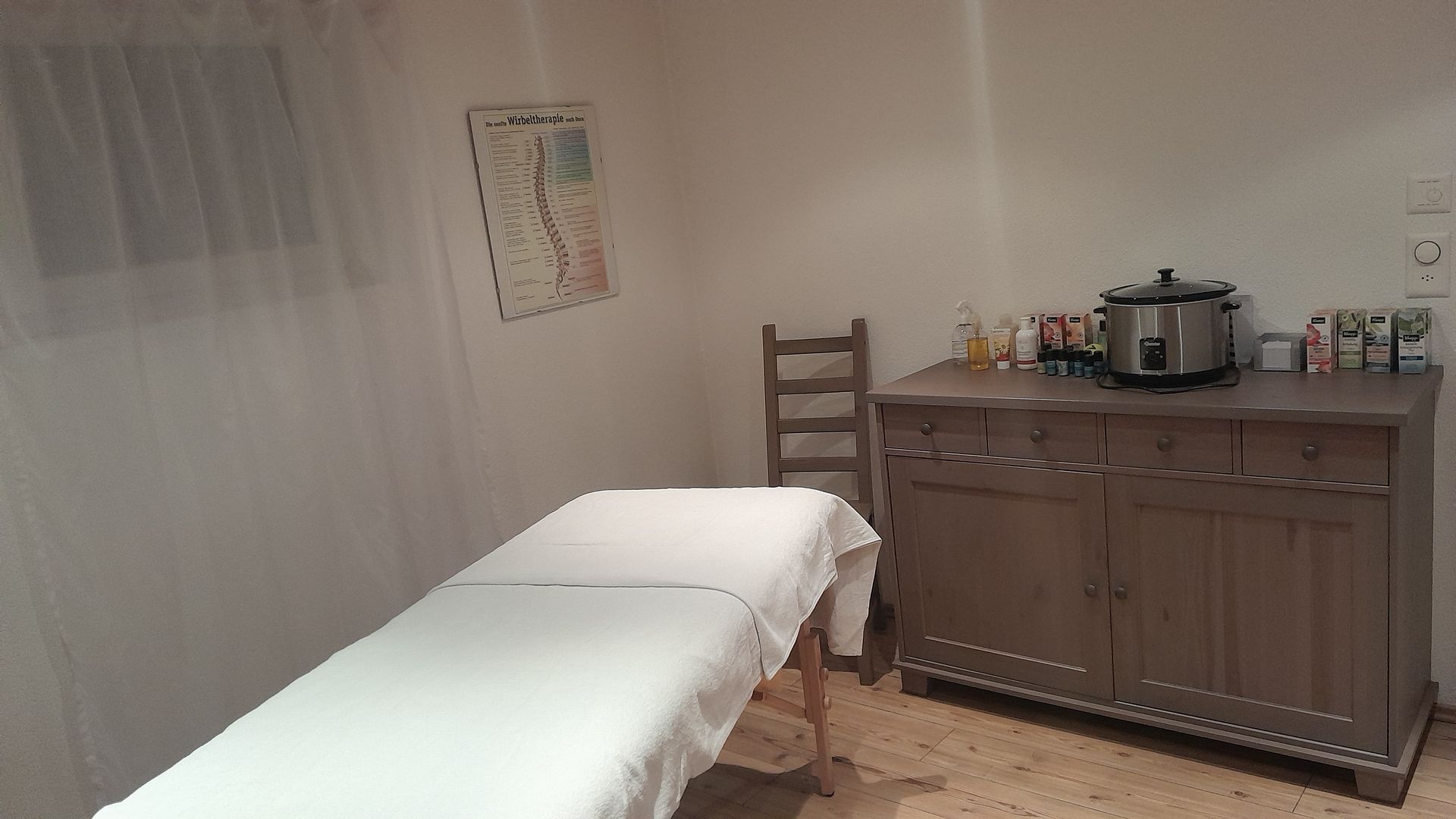 In der Mitte des Raumes steht ein Massagetisch.