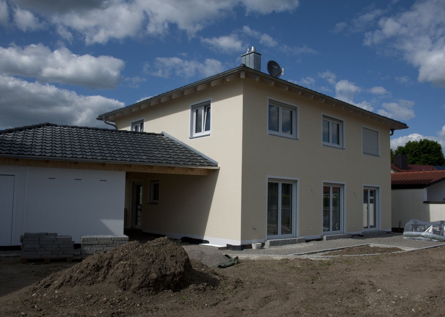 Cremefarbiges Fertigteilhaus inklusive Garage, Fertigteilhaus in Weiß, Kleber Hausbau