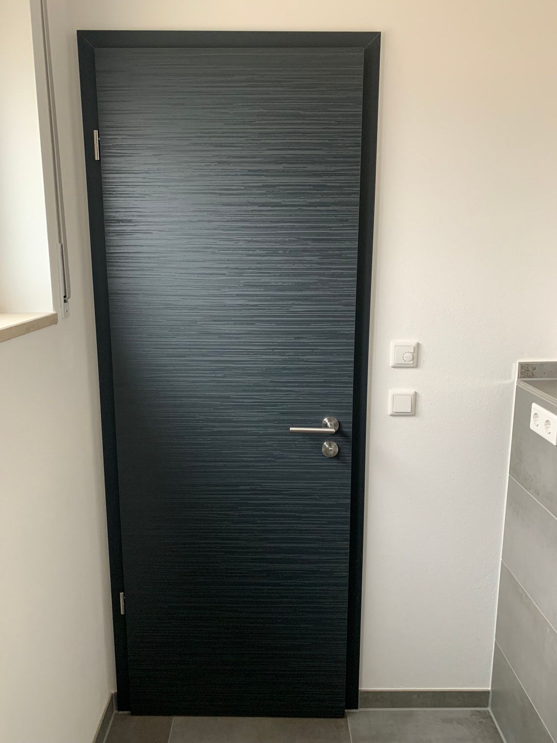 Dunkelgraue Tür, Kleber Hausbau