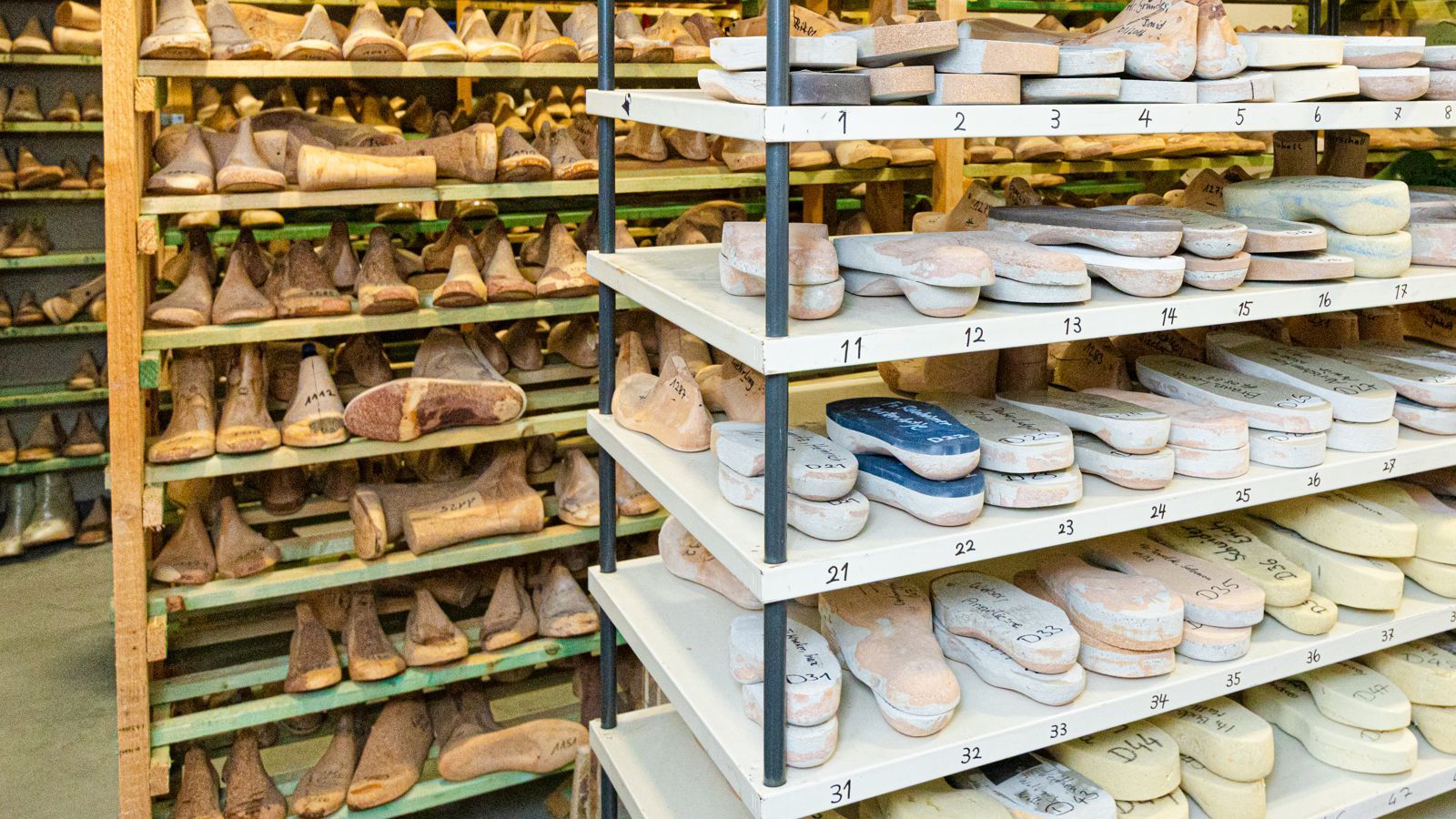 Ein Paar Schuhe und Einlegesohlen liegen auf einem Holztisch.