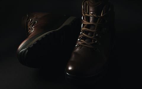 Ein Paar braune Lederstiefel auf schwarzem Hintergrund.