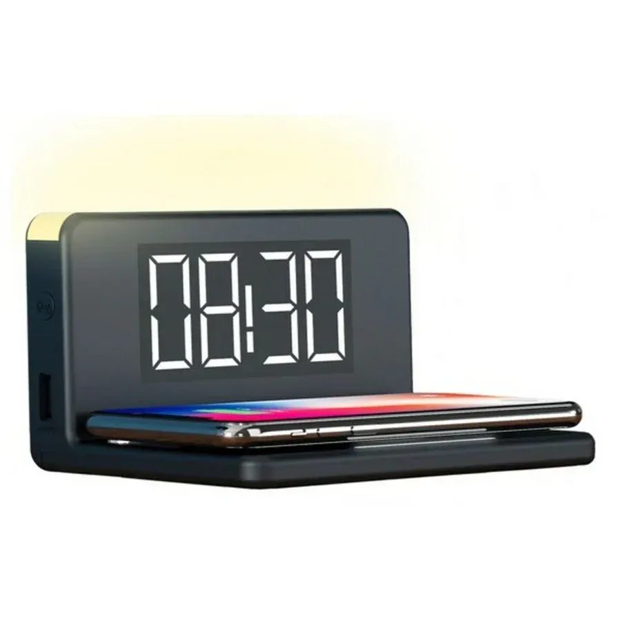 Un reloj digital está encima de un cargador inalámbrico.
