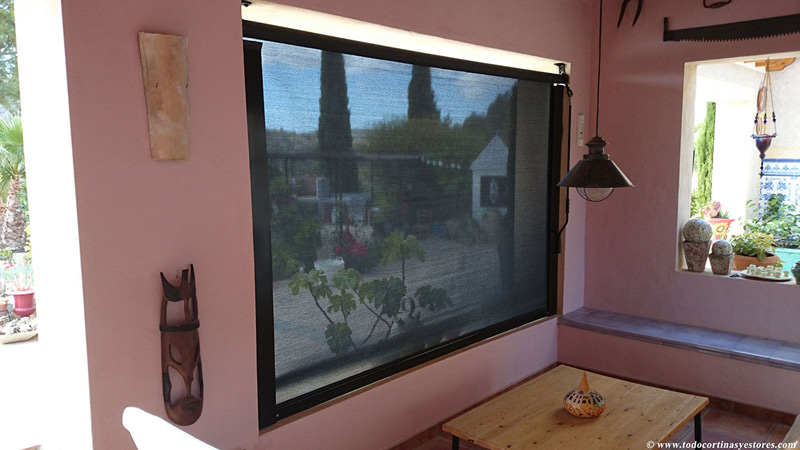 Una habitación con una gran ventana y una mesa de madera.