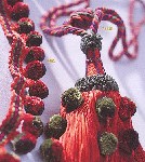 Un primer plano de un collar con cuentas rojas y verdes sobre una mesa.