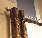 Un primer plano de un par de cortinas marrones colgadas en una ventana.