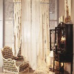 Una sala de estar con una silla, una cómoda y cortinas.