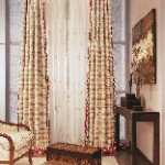 Una sala de estar con una silla, una mesa y cortinas.