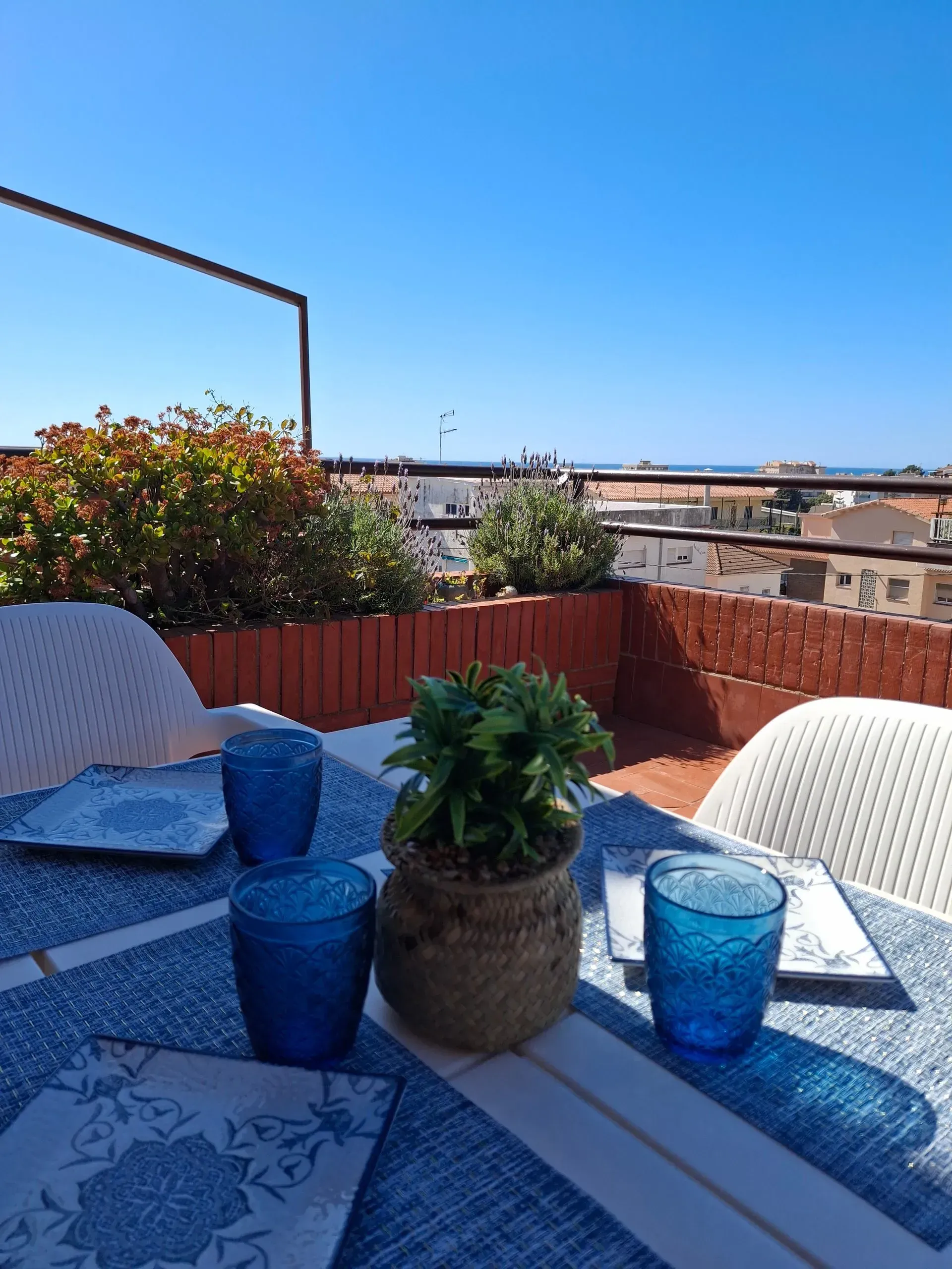 Una mesa con vasos y platos azules encima.