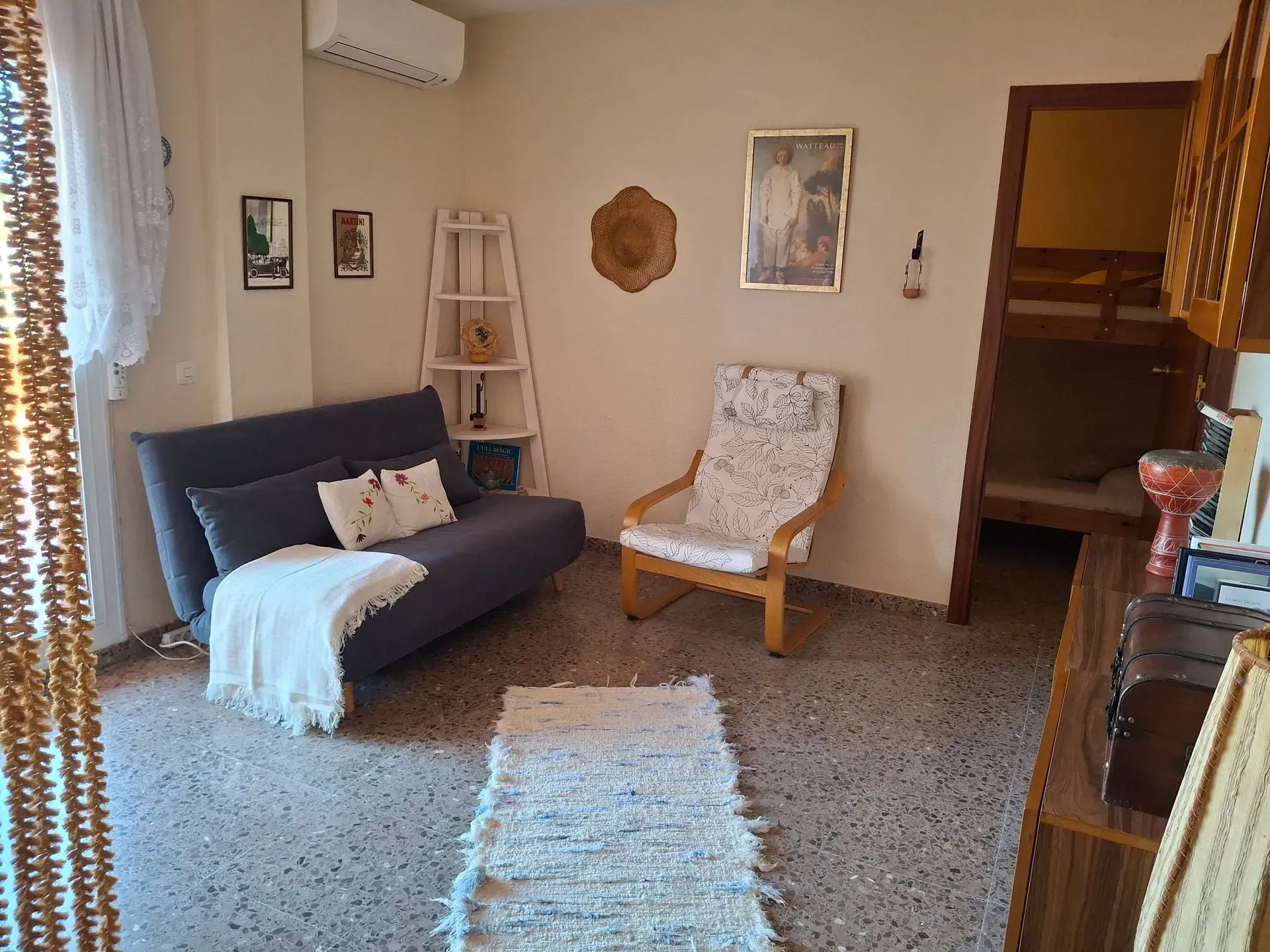 Una sala de estar con un sofá, una silla y una alfombra.