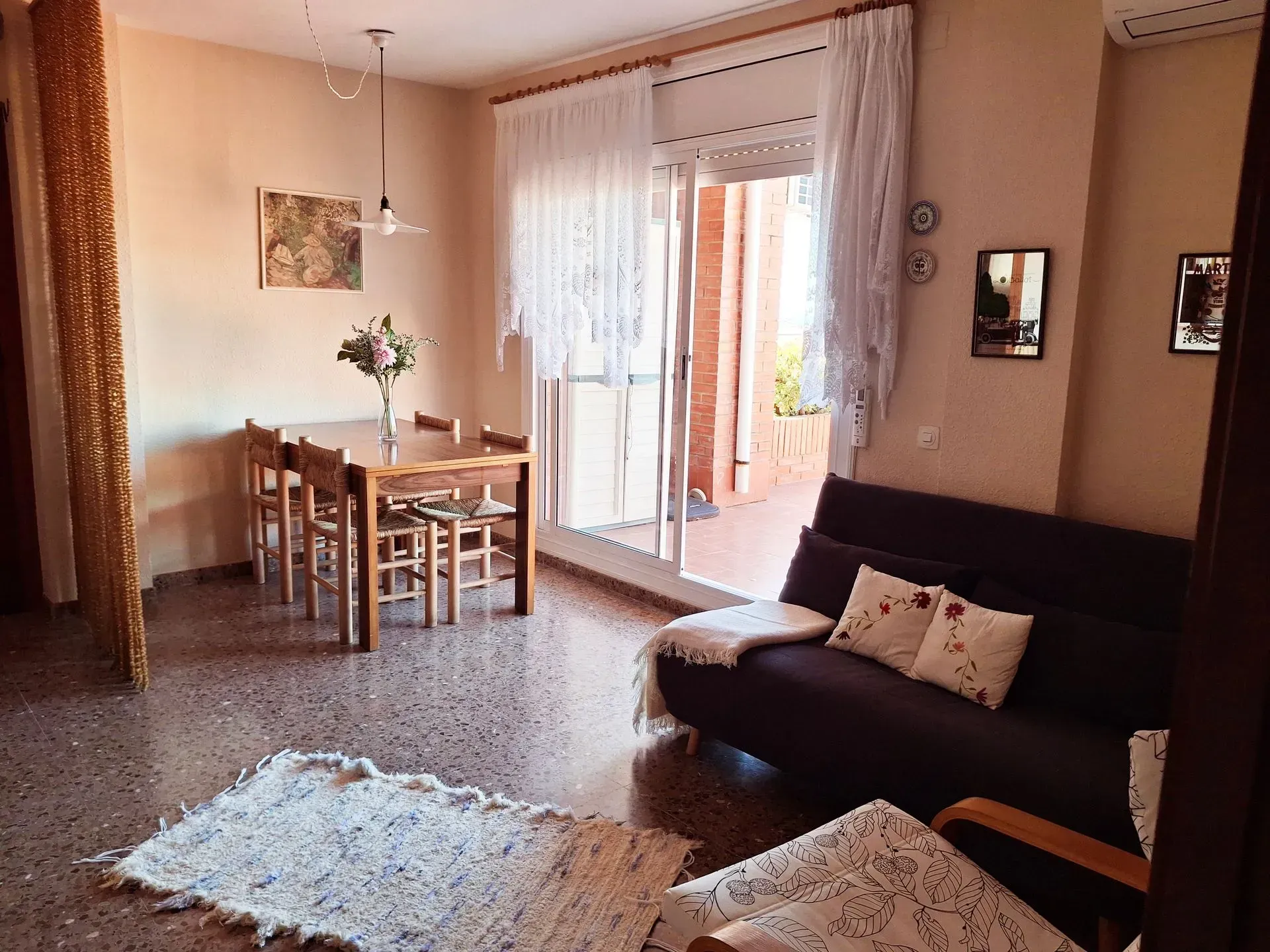 Una sala de estar con un sofá, una mesa y sillas.