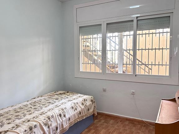 Un dormitorio con una cama individual y una gran ventana.