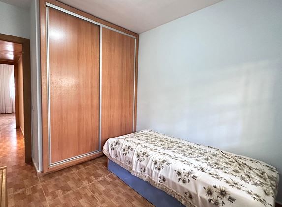 Un dormitorio con una cama individual y un gran armario.