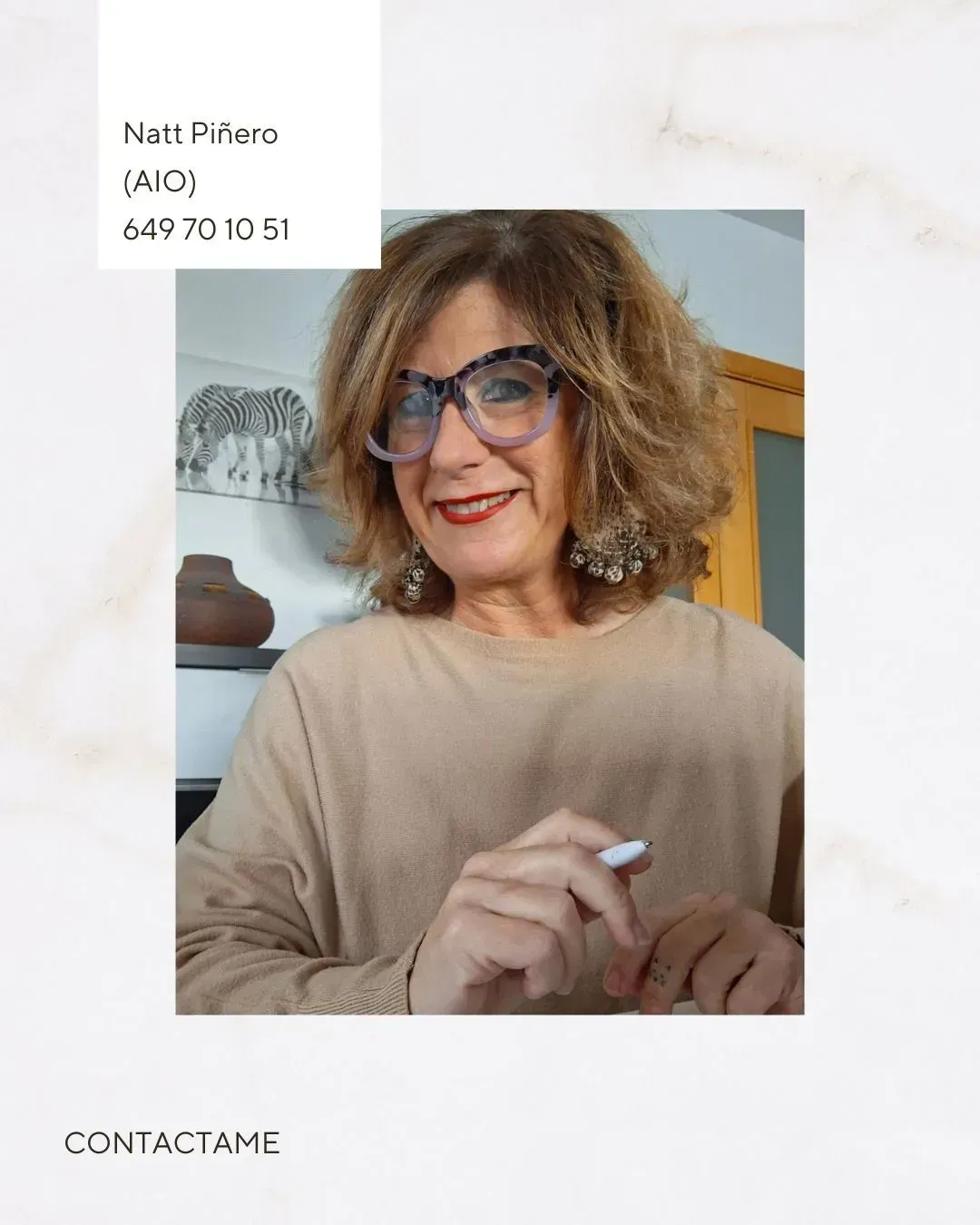 Una mujer que lleva gafas sostiene un bolígrafo en la mano.