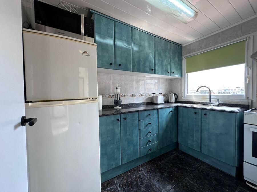 Cocina azul con electrodomésticos blancos.