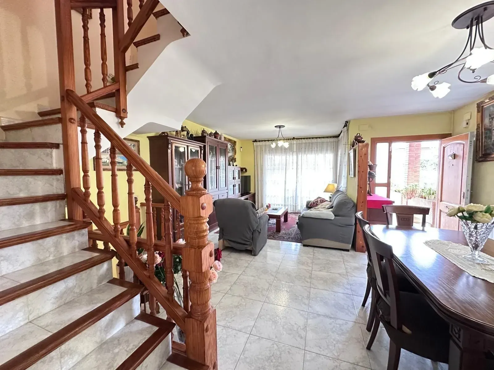 Una sala de estar con una escalera que conduce al segundo piso.