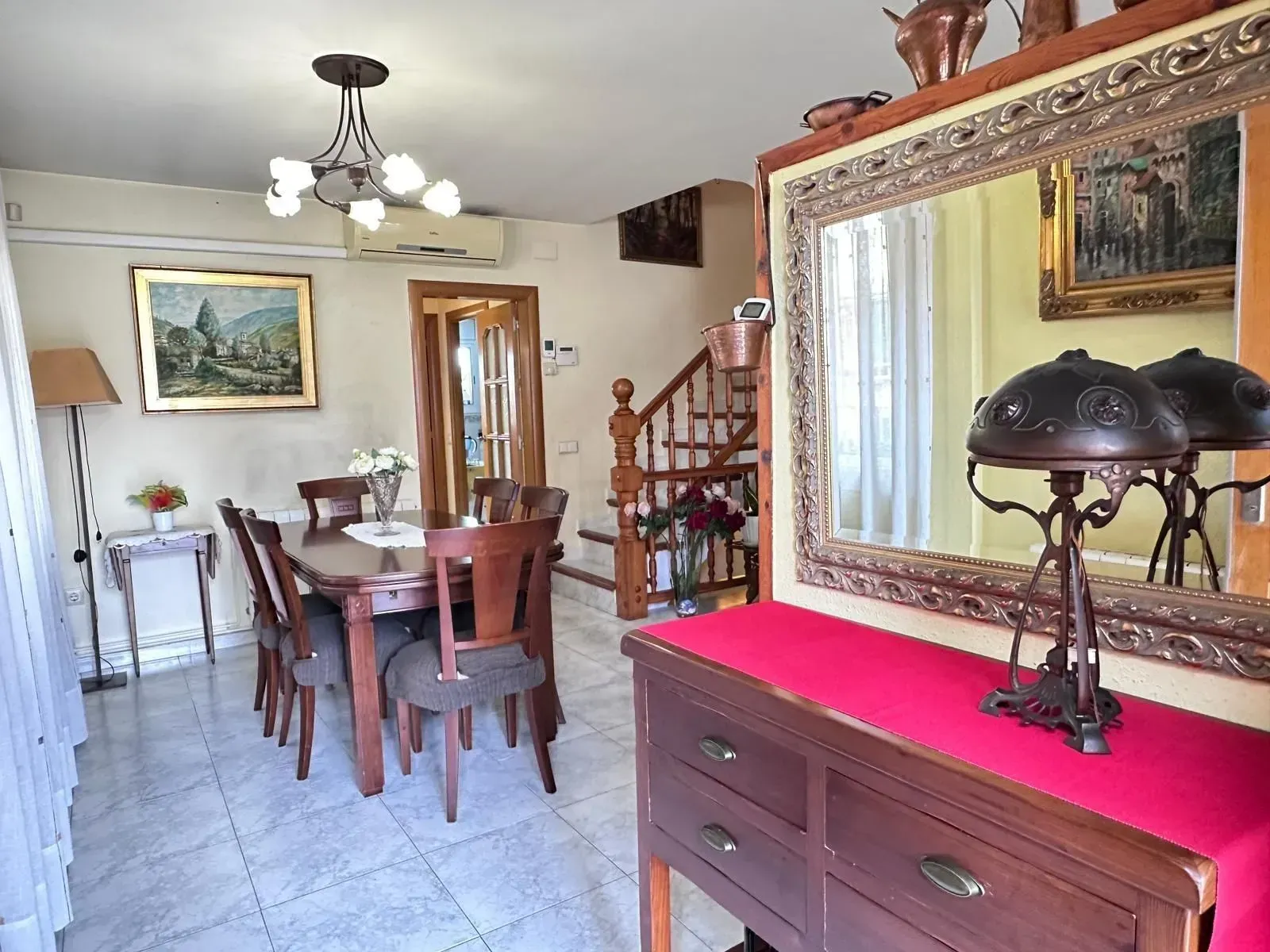 Un comedor con una mesa y sillas y un espejo.