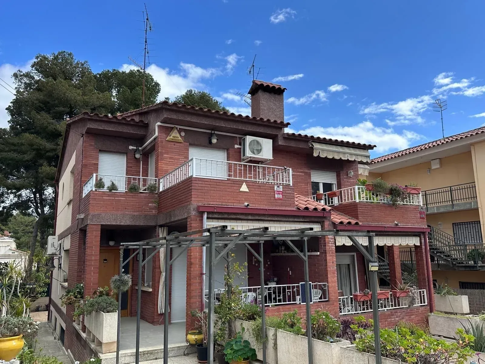 Una gran casa de ladrillo con un gran aire acondicionado en el techo.