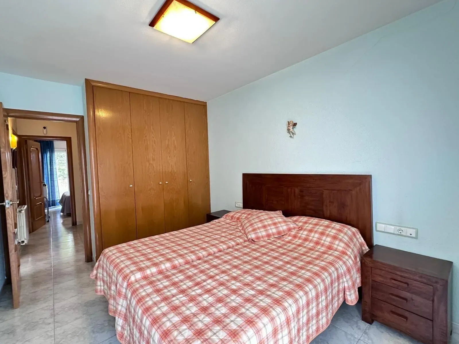 Un dormitorio con una cama grande y una mesita de noche.