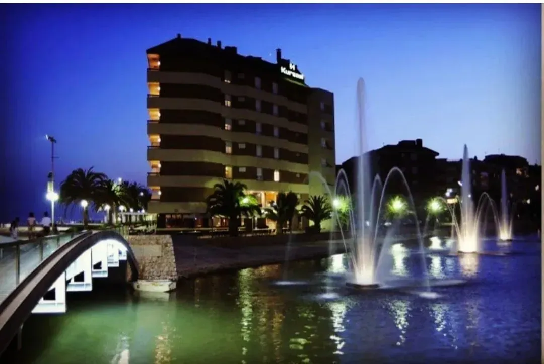 Una fuente frente a un edificio por la noche