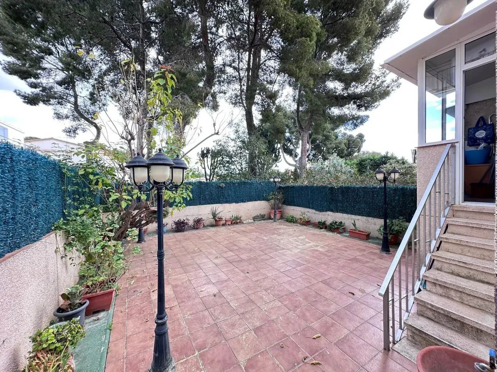 Un patio con escaleras y una farola delante de una casa.