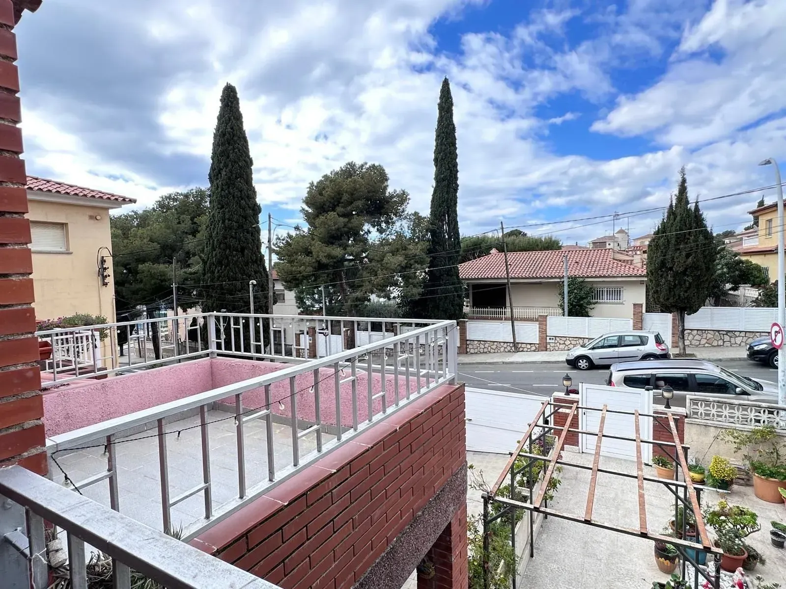 Un balcón con vista a una calle y árboles.