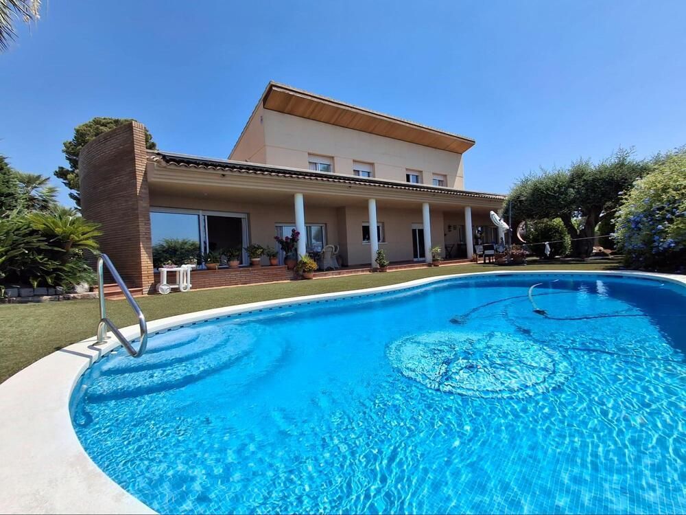 Una casa grande con piscina delante de ella.