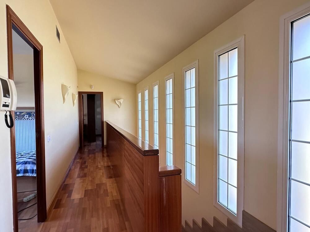 Un largo pasillo con muchas ventanas y escaleras.