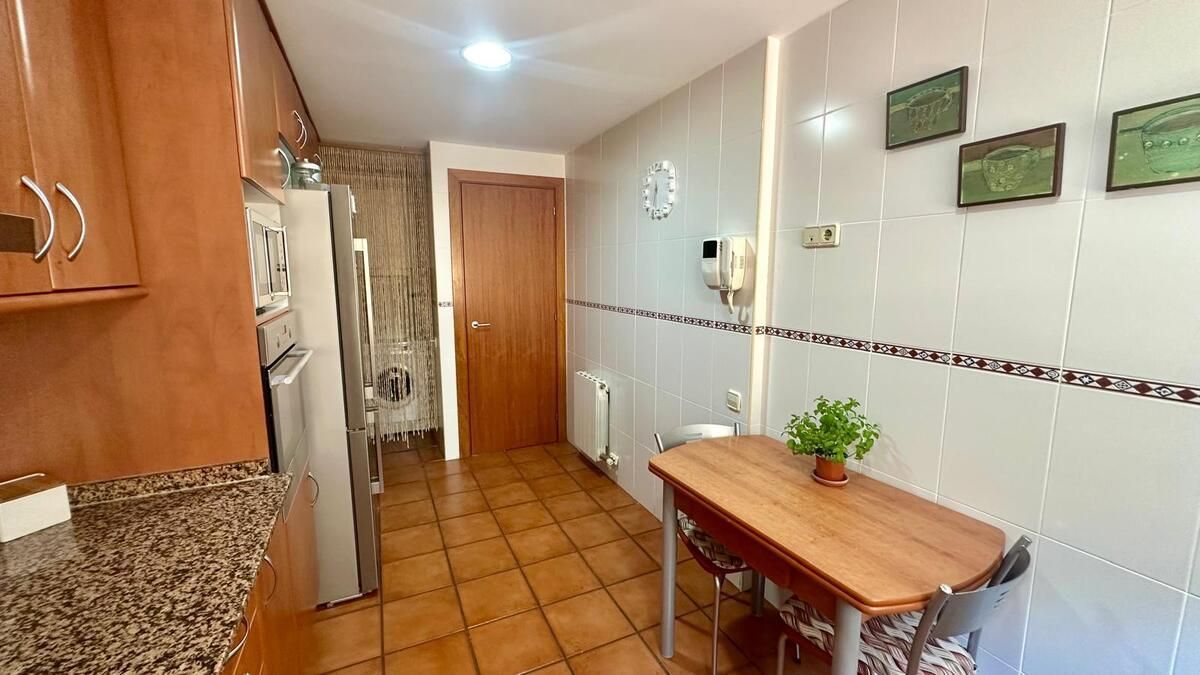 Una cocina con mesa y sillas y un frigorífico.