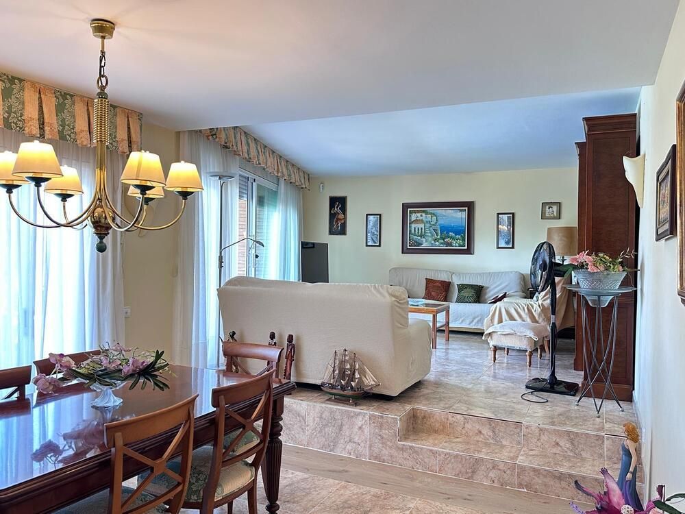 Una sala de estar con una mesa y sillas y una lámpara de araña.