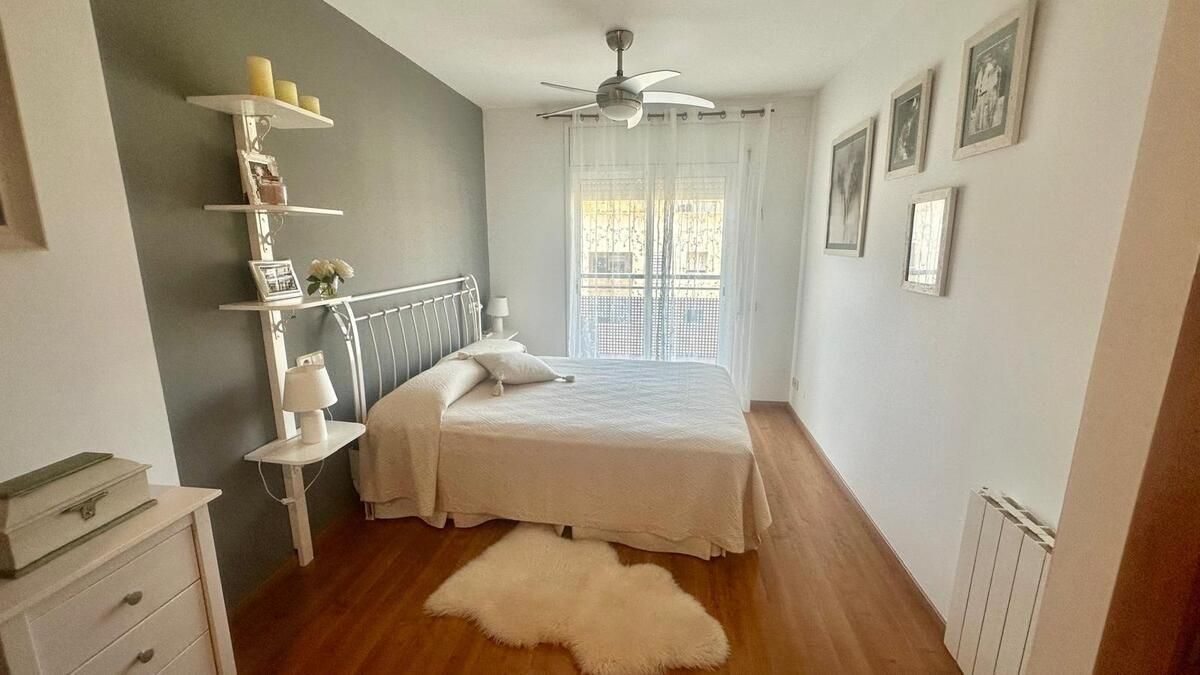 Un dormitorio con una cama grande y un ventilador de techo.