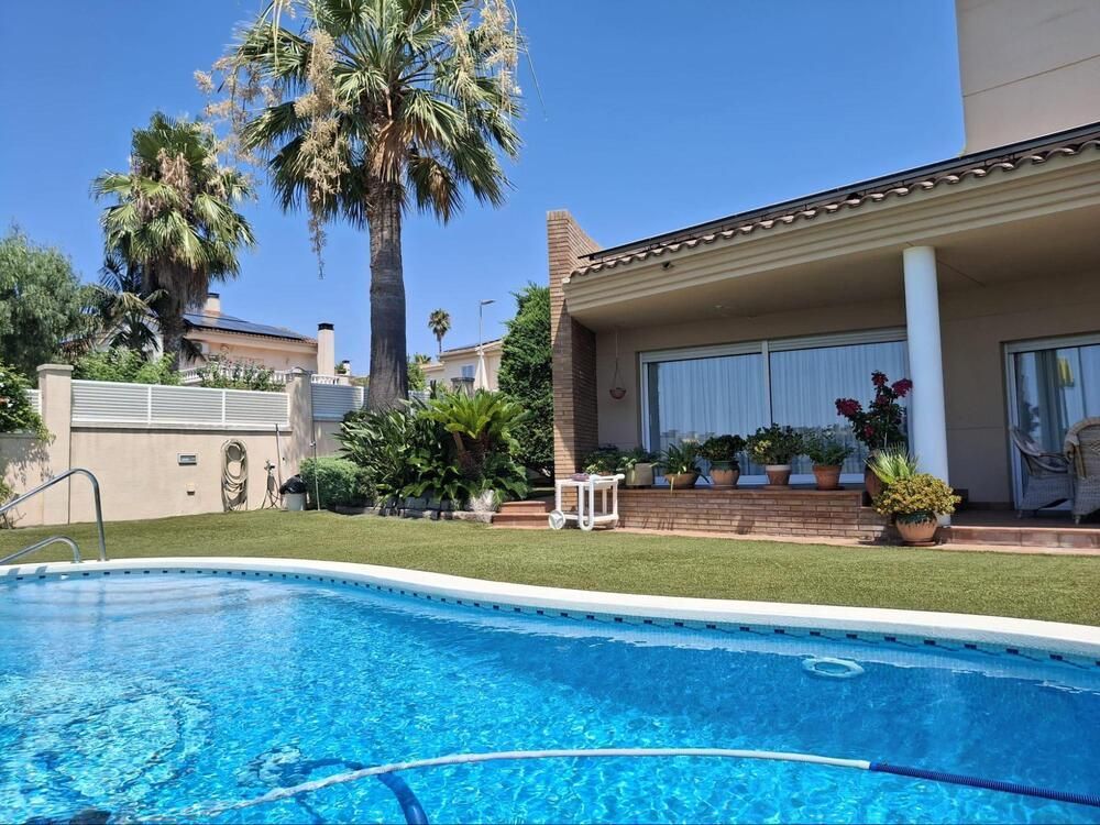 Una casa grande con piscina delante de ella.