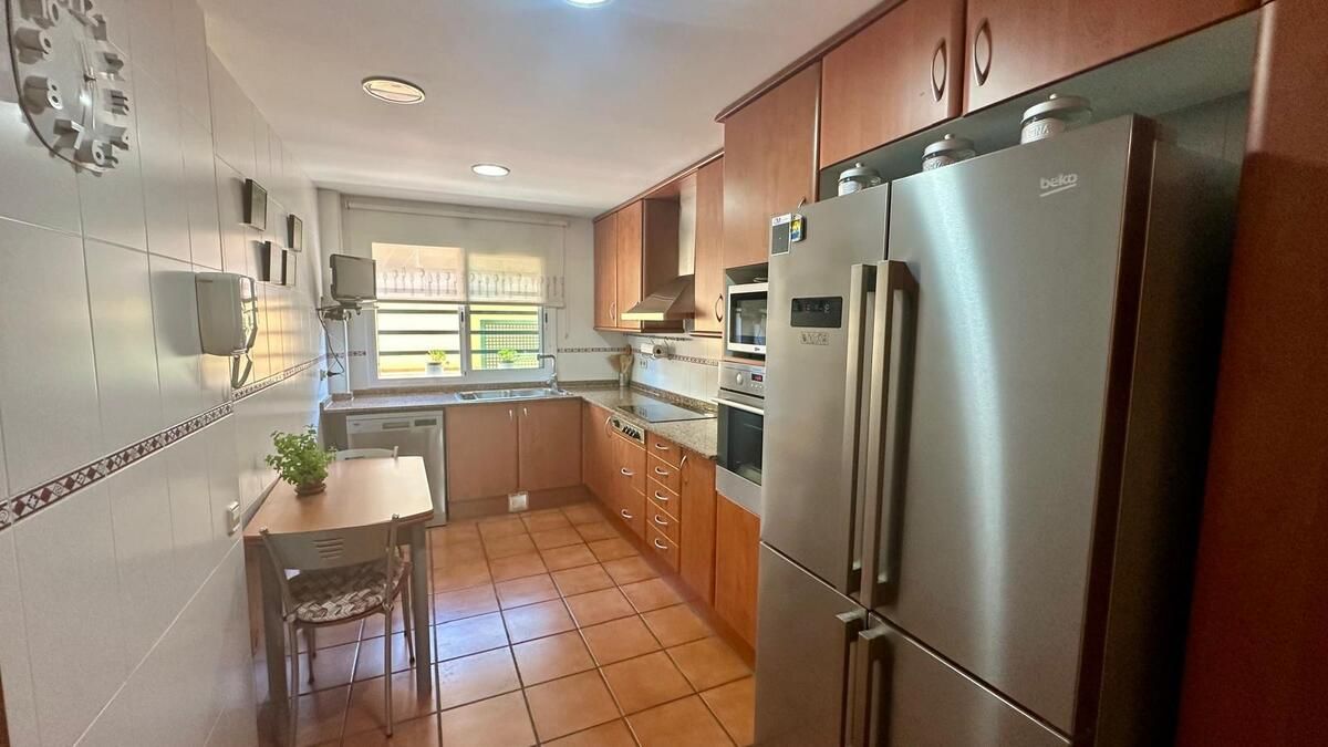 Una cocina con electrodomésticos de acero inoxidable y gabinetes de madera.