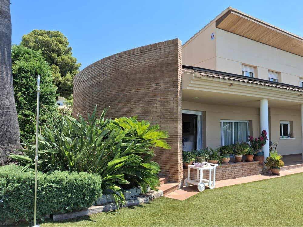 Una casa grande con un lado curvo y un césped delante de ella.