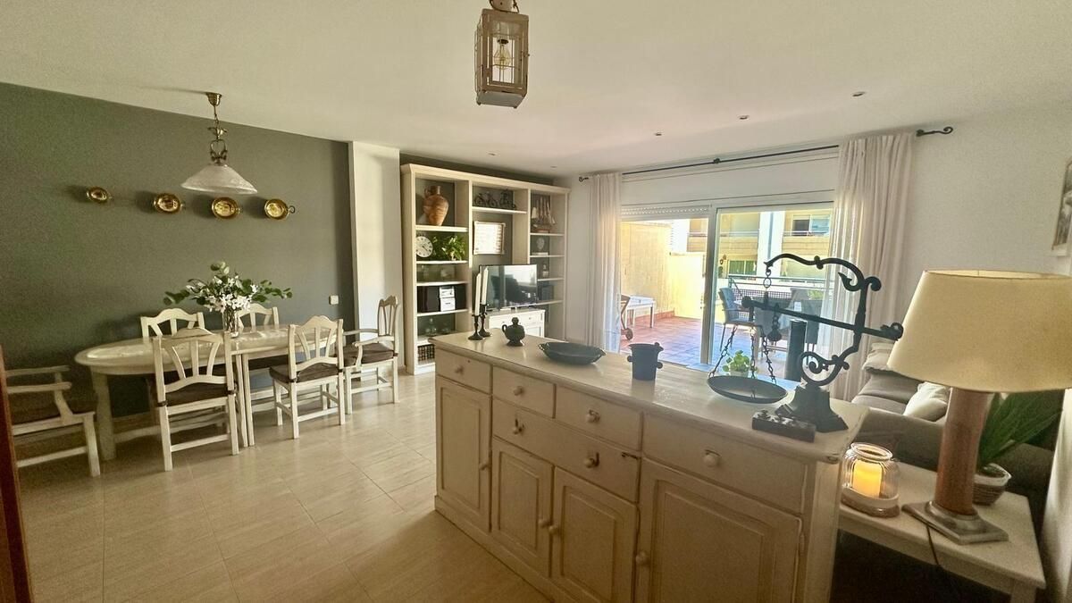 Una sala de estar con una mesa y sillas y una lámpara.