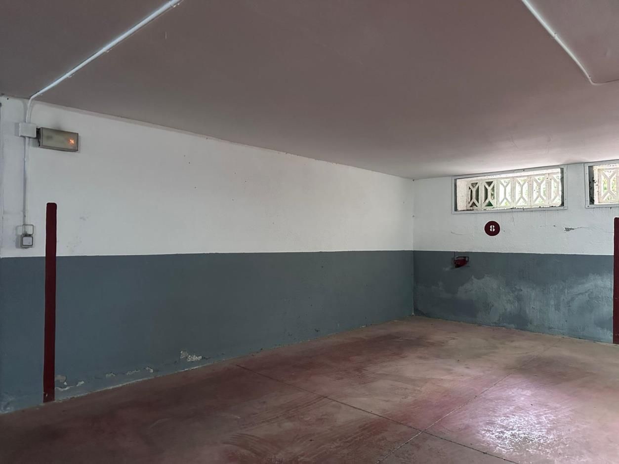 Garaje vacío, pintado de gris, con una pared bitono. Techo blanco.