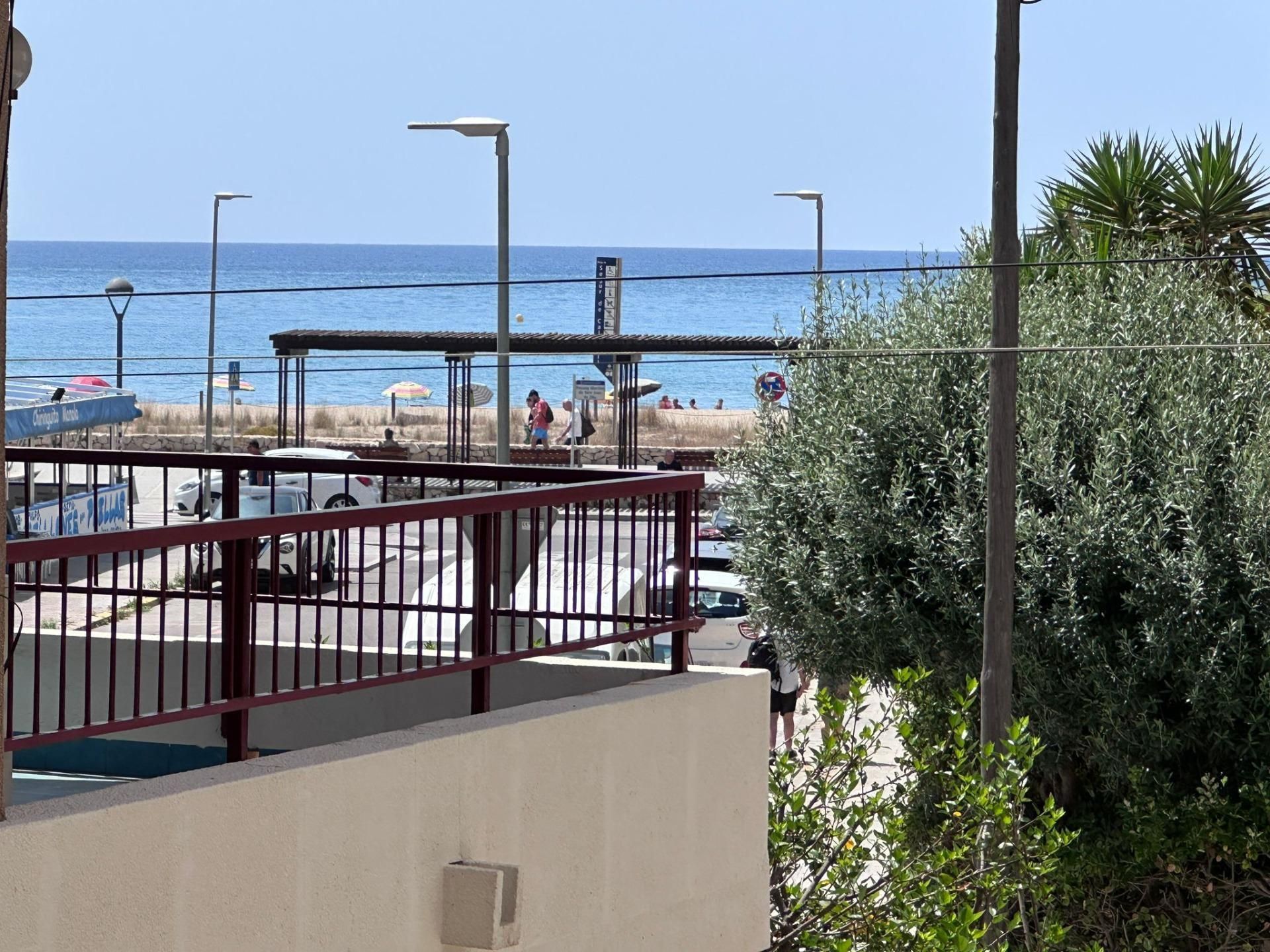 Una vista del océano desde un balcón con barandilla roja.